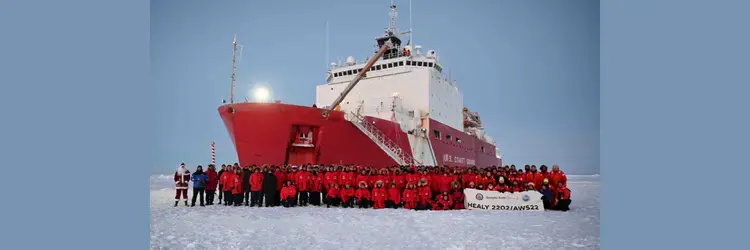 USCGC Healy in the ice, with crew in front of ship