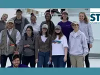 Photo of StemSEAS Participants on a ship with logo in upper right corner